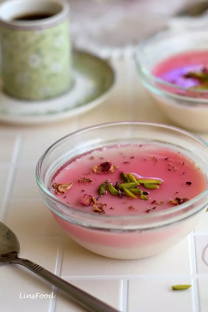 Rose syrup panna cotta in a small glass bowl, topped with undiluted homemade rose syrup