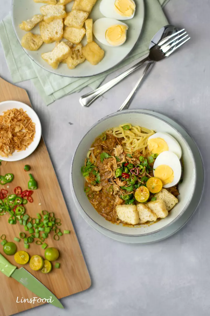 mee rebus (egg noodles) topped with eggs, tofu, chillies limes and gravy
