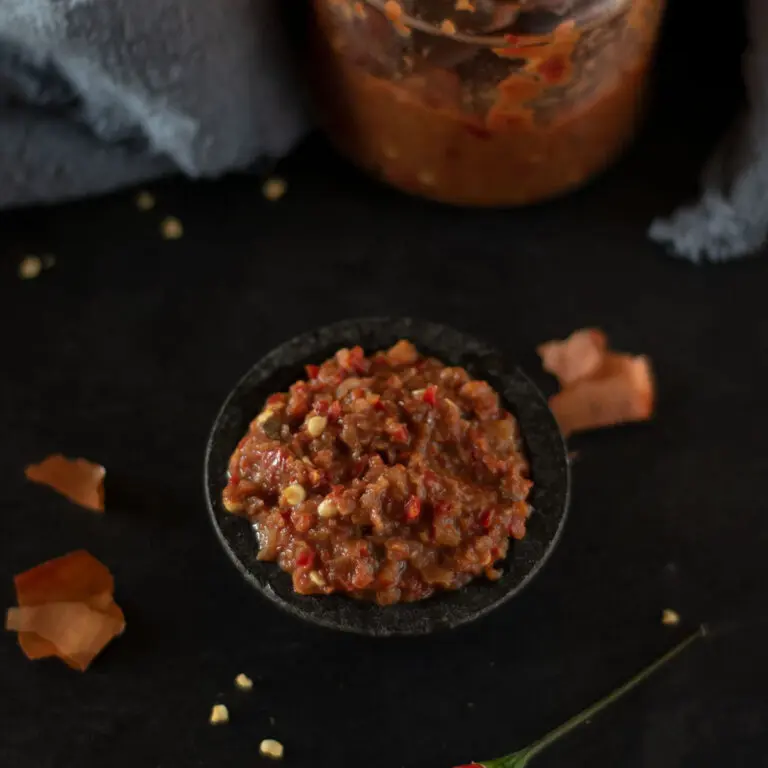 sambal belacan bawang, red chilli paste in a small black bowl