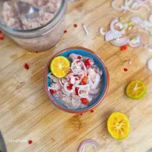 Easy sambal cincalok recipe with fermented shrimp, shallots, red chilli and calamondin lime in a small bowl.