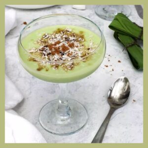 Pandan Mahalabia, light green pudding, in a champagne saucer topped with brown sugar shavings
