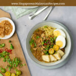 mee rebus photo (egg noodles) topped with eggs, tofu, chillies limes and gravy