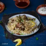 Chicken Biryani on a large plate with lemon slices