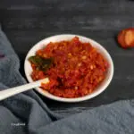 sambal balado, red chilli paste in a small white bowl with white spoon