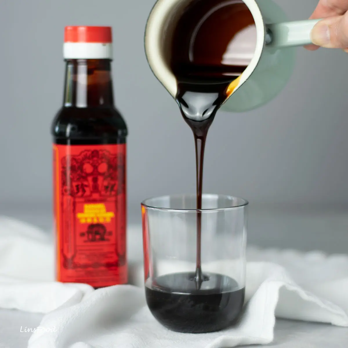 pouring thick, dark cooking caramel sauce into jar
