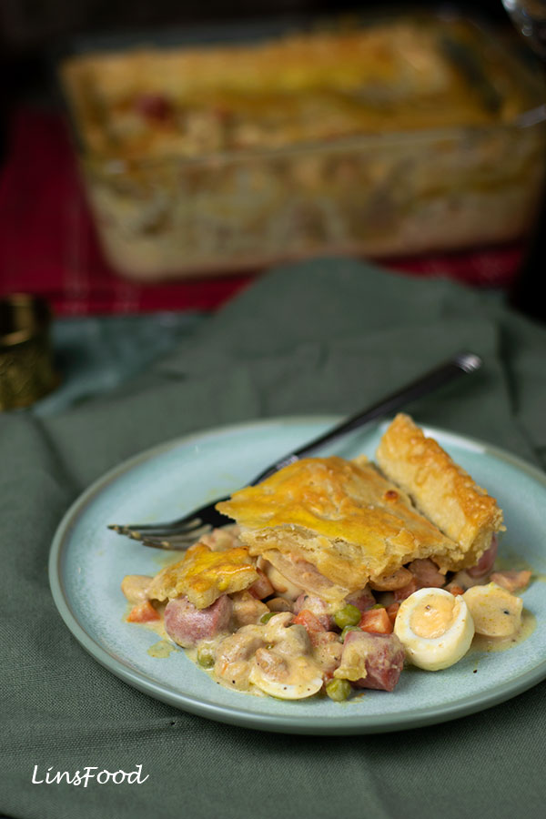 Eurasian Christmas Pie slice on a plate with sausages and quail eggs