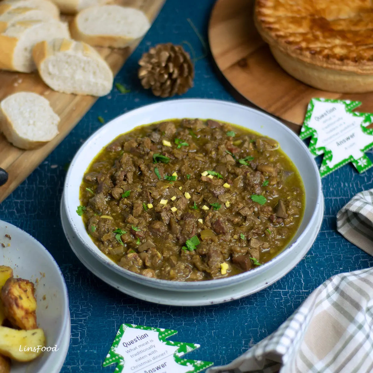 curry feng, a Eurasian offal curry in a blue bowl with Eurasian Christmas Pie and baguette in the background
