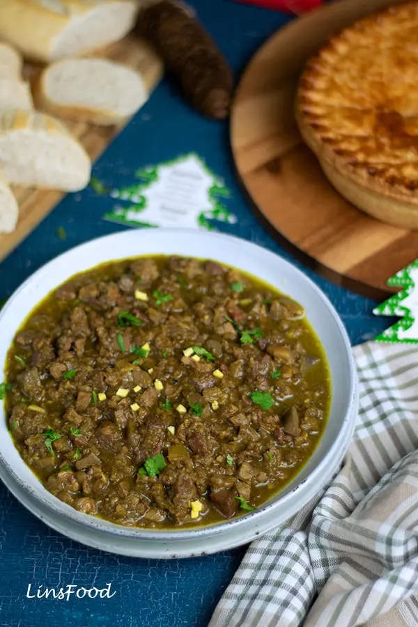 curry feng, a Eurasian offal curry in a blue bowl with Eurasian Christmas Pie and baguette in the background