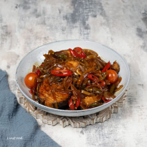 soy limang fish (Eurasian fish) with soy sauce in pale bowl with lots of onions and red chillies