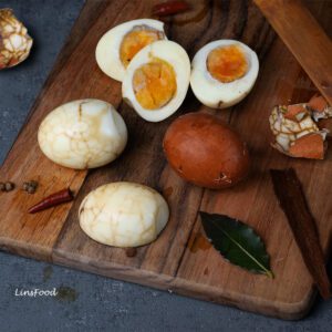 chinese tea eggs on a wooden board, sliced half boiled eggs