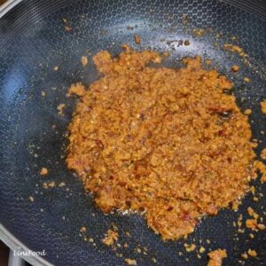 Rempah or bumbu oil separation while frying, red chilli paste turning darker with orange oil splitting around the paste. Pecah Minyak in Malay