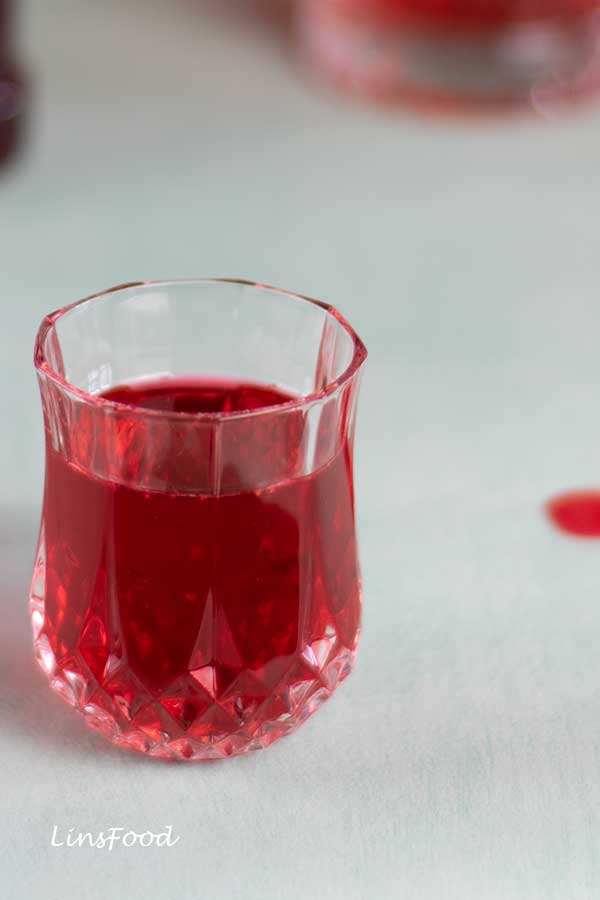 Concentrated homemade rose syrup (sirap ros) in a crystal shot glass, close-up