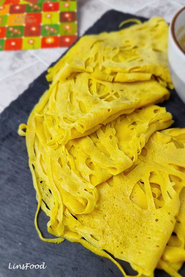 Close-up of soft, lacy roti jala showing the delicate net-like pattern.