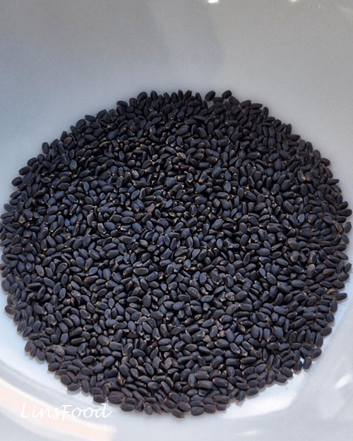 Dry black basil seeds in a white bowl before soaking.