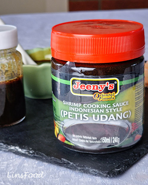 Jar of Jeeny's Petis Udang shrimp cooking sauce beside homemade petis udang