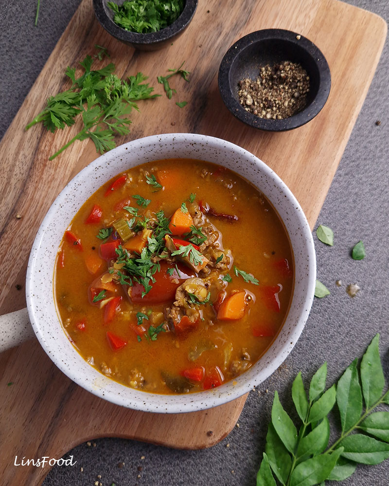 Beef and red lentil mulligatawny soup with carrots, tomatoes, celery and red capsicum, garnished with fresh coriander.