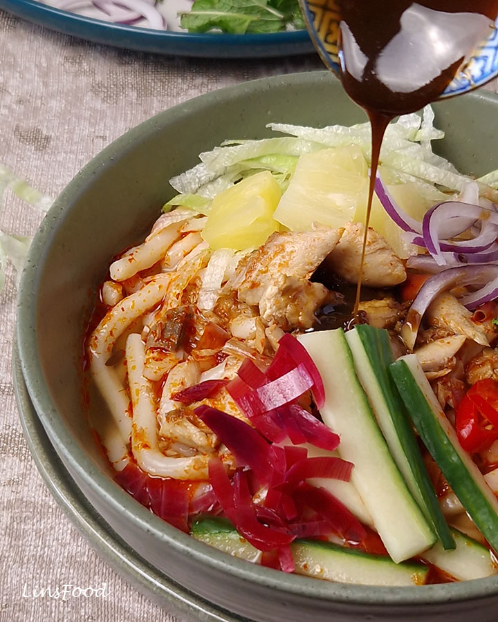 Petis udang being drizzled over a bowl of Penang asam laksa